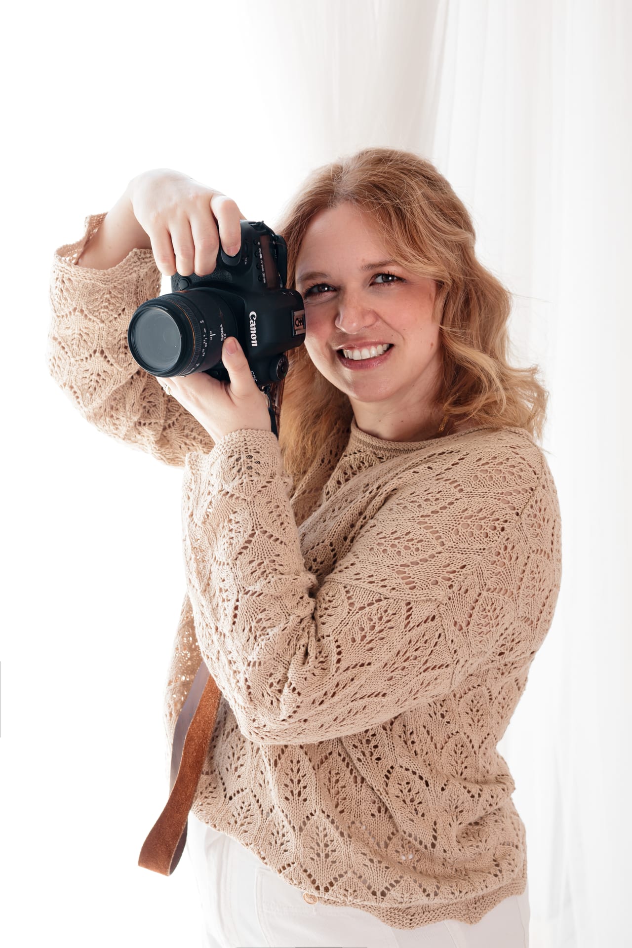 Susana Schmitz com câmara Canon nas mãos, fotógrafa profissional em ação no estúdio em Leça da Palmeira, Porto