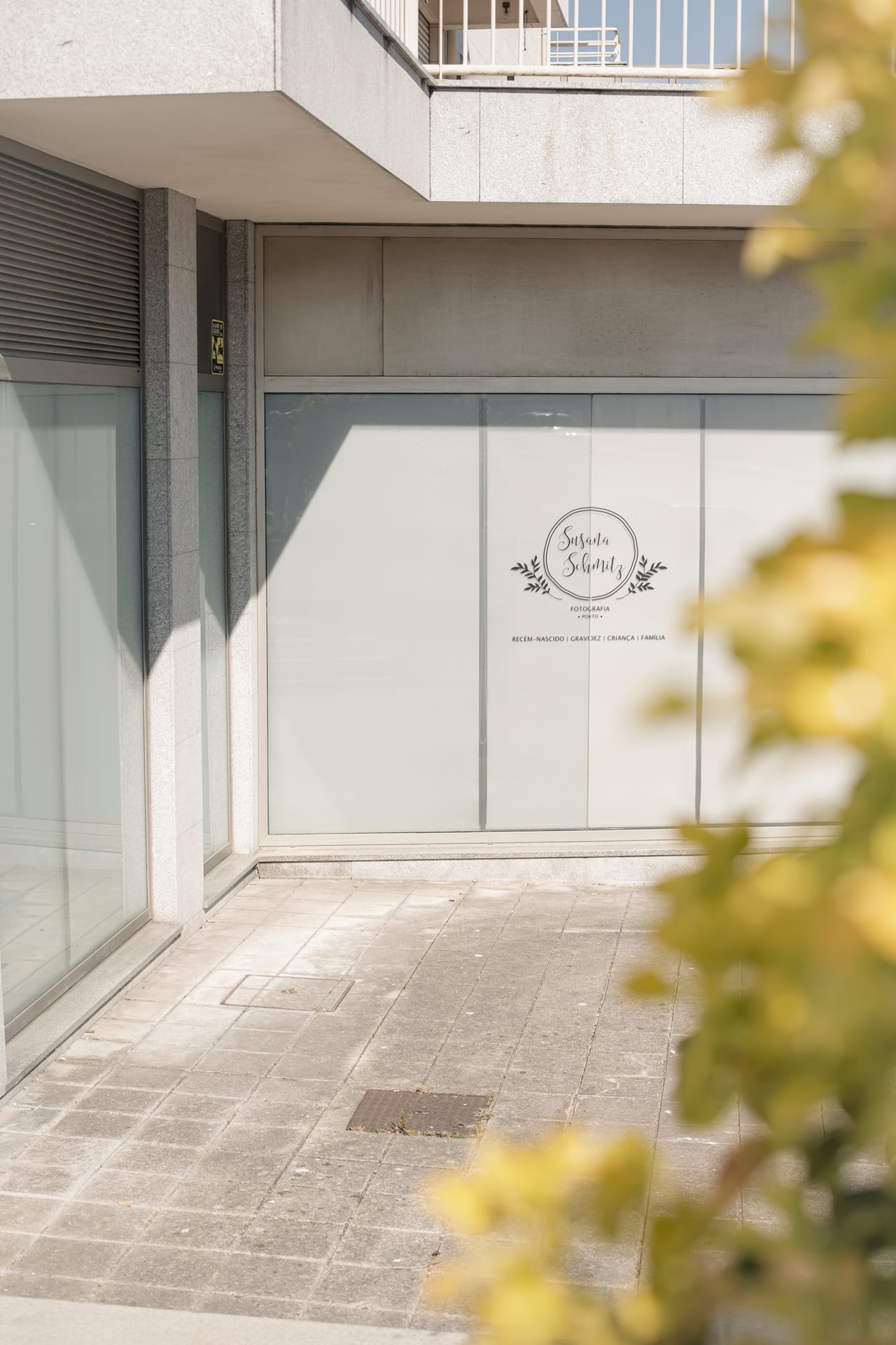 Fachada do estúdio Susana Schmitz Fotografia Porto vista do exterior, com decal de serviços (recém-nascido, gravidez, criança, família) na vitrine envidraçada, Leça da Palmeira