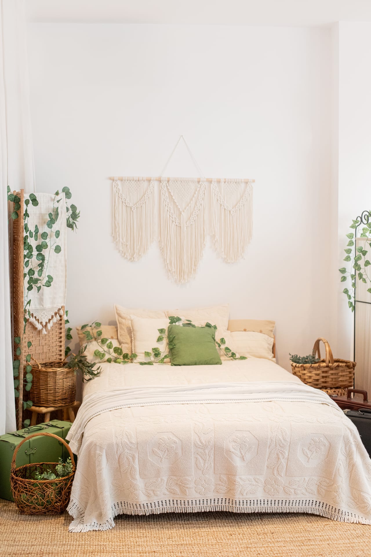 Cama montada para sessões de gravidez e família com colcha cremosa, almofada verde e macramé na parede, estúdio Susana Schmitz, Porto