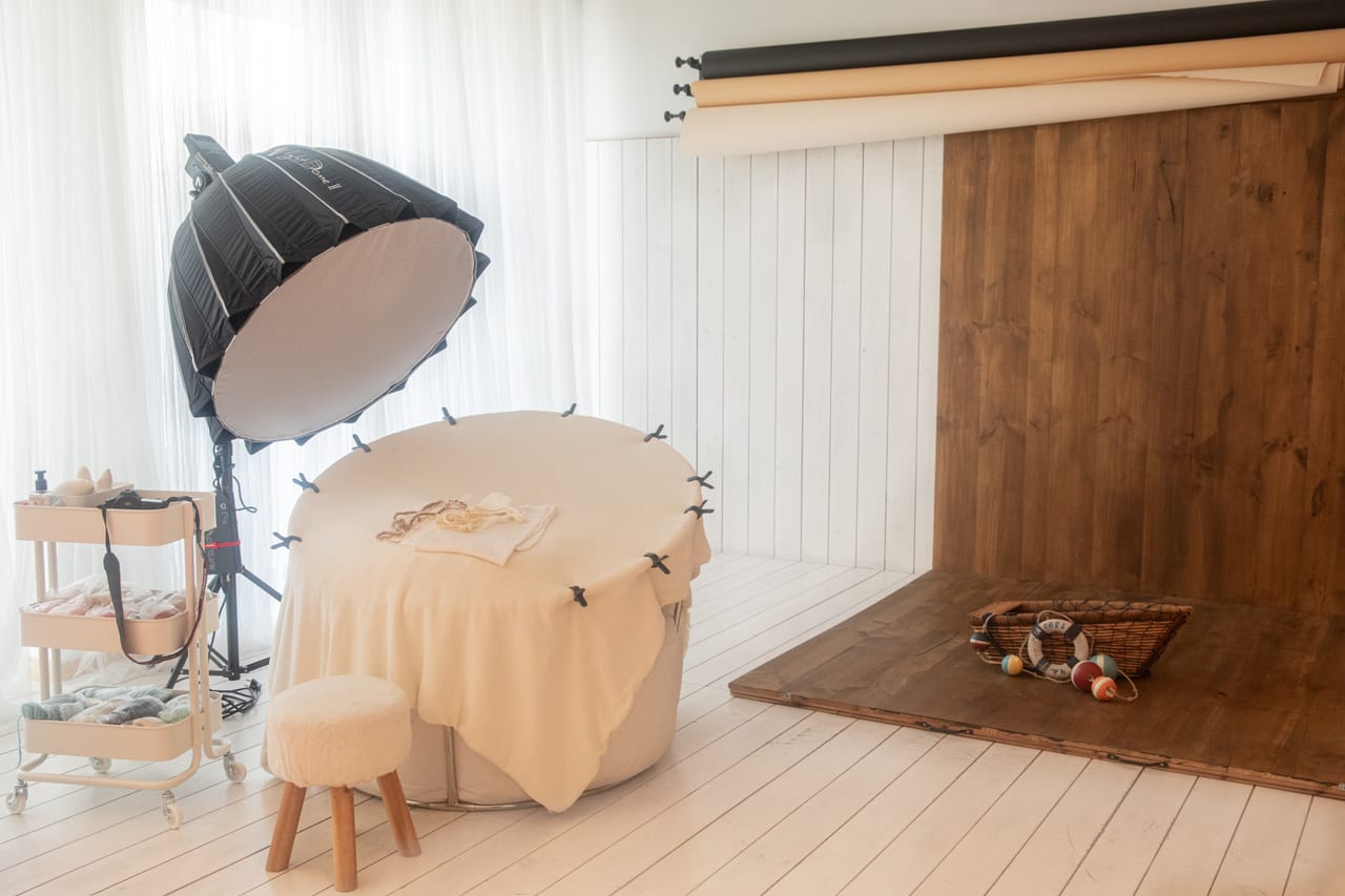 Vista ampla da zona de sessão do estúdio com beanbag oval, octa softbox e fundos de papel ao lado de cenário em madeira, Susana Schmitz Fotografia, Leça da Palmeira