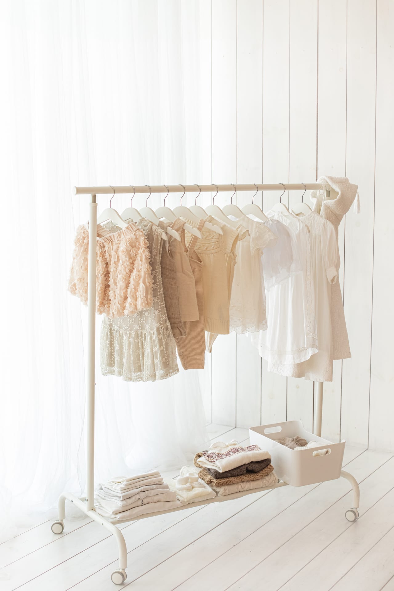 Rack de guarda-roupa para bebés e crianças com vestidos e conjuntos em renda, linho e malha em tons cremes e beges, estúdio Susana Schmitz, Porto