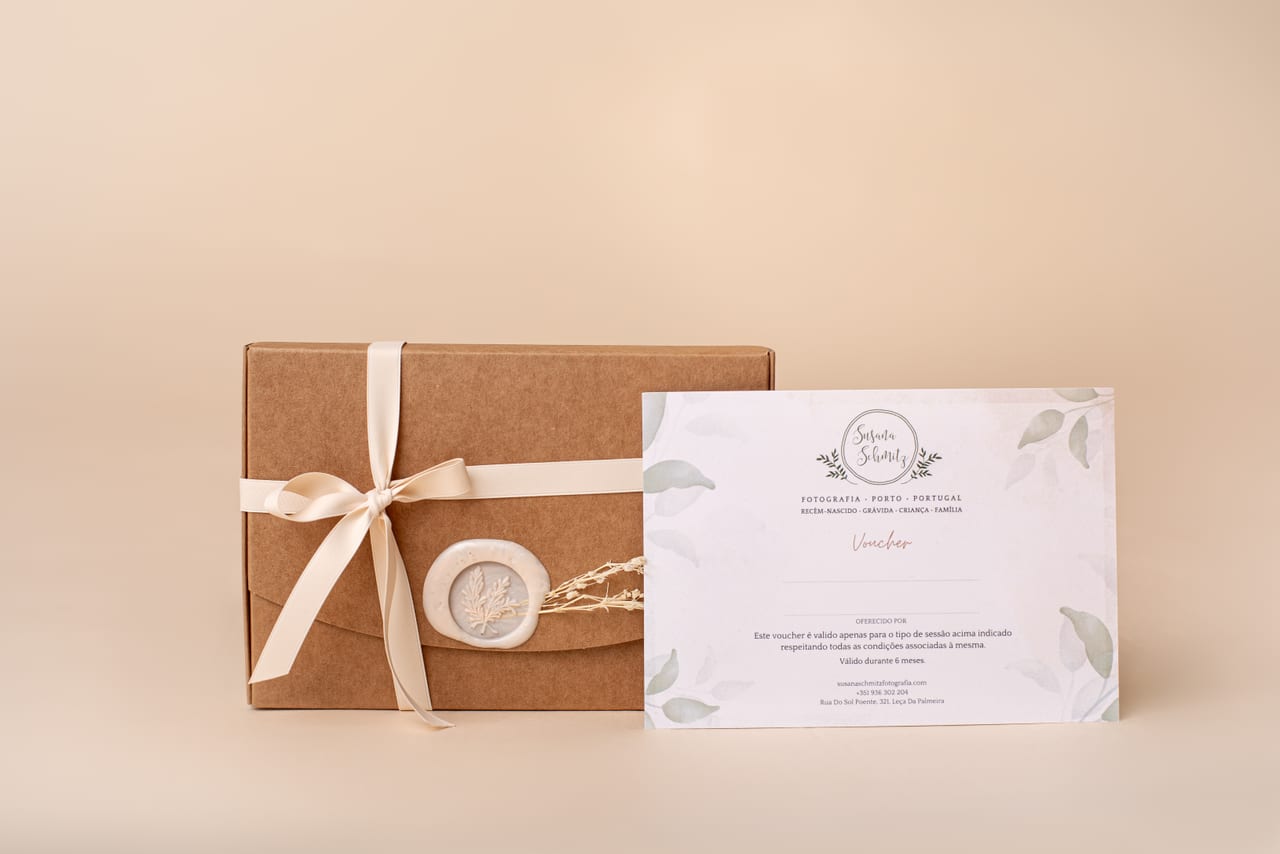 Voucher Susana Schmitz Fotografia impresso com decoração botânica ao lado de caixa kraft fechada com fita de cetim, selo de lacre e ramo de flores secas, sobre fundo pêssego, Porto