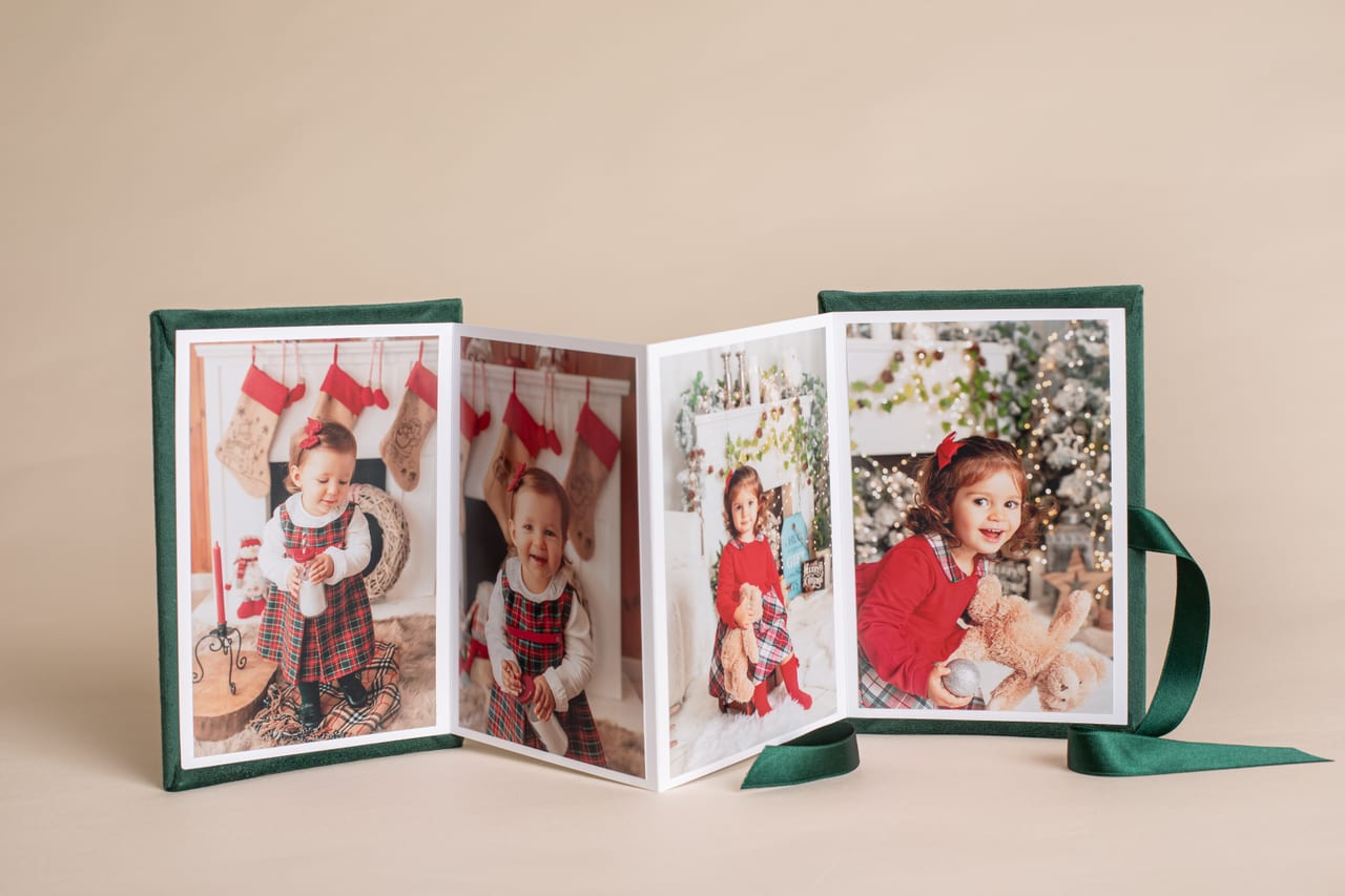 Accordion folio em veludo verde aberto em zigue-zague com quatro impressões de sessão temática infantil de Natal, Susana Schmitz Fotografia, Porto