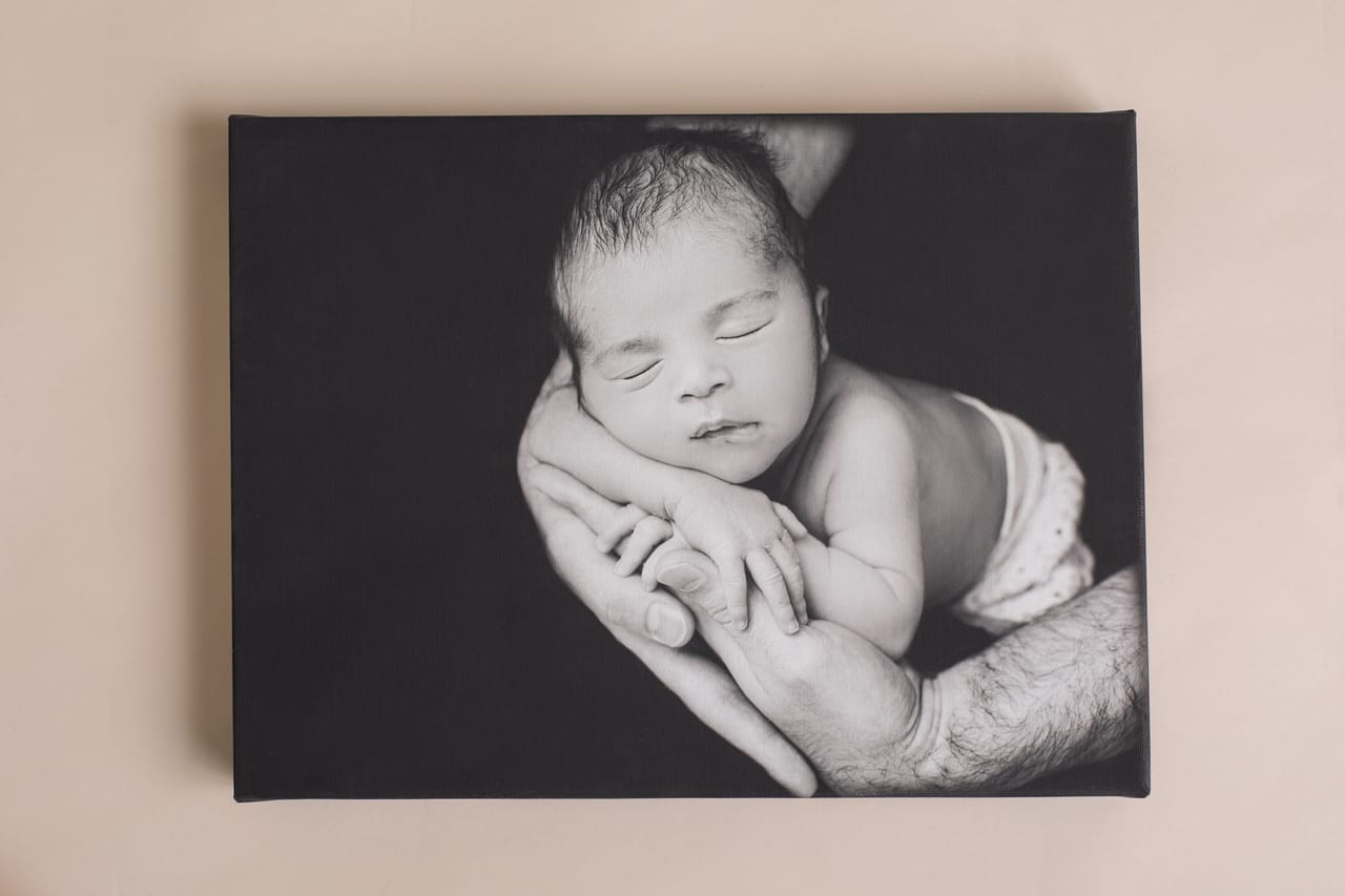 Tela canvas 30x40 em preto e branco com fotografia de recém-nascido nas mãos dos pais, Susana Schmitz Fotografia, Porto