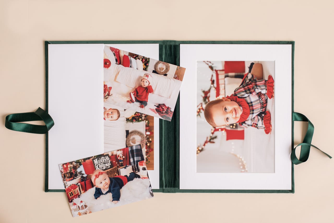 Folio analógico em veludo verde aberto com impressão grande de sessão temática de Natal e impressões mais pequenas intercambiáveis ao lado, fita de cetim verde, produto Susana Schmitz Fotografia, Porto