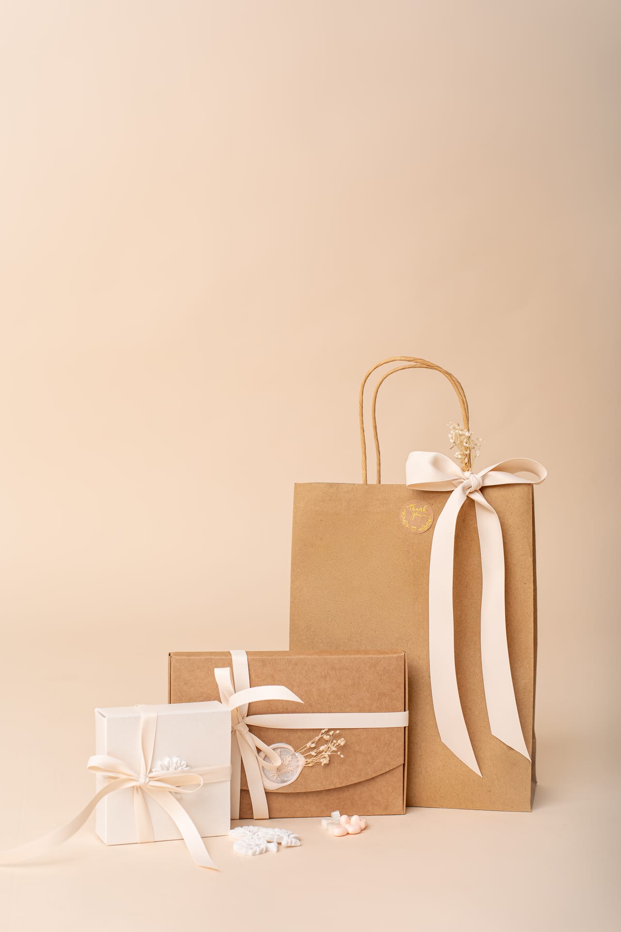 Apresentação do packaging Susana Schmitz: saco kraft com fita de cetim, caixa kraft selada e caixa branca com flores secas, Porto