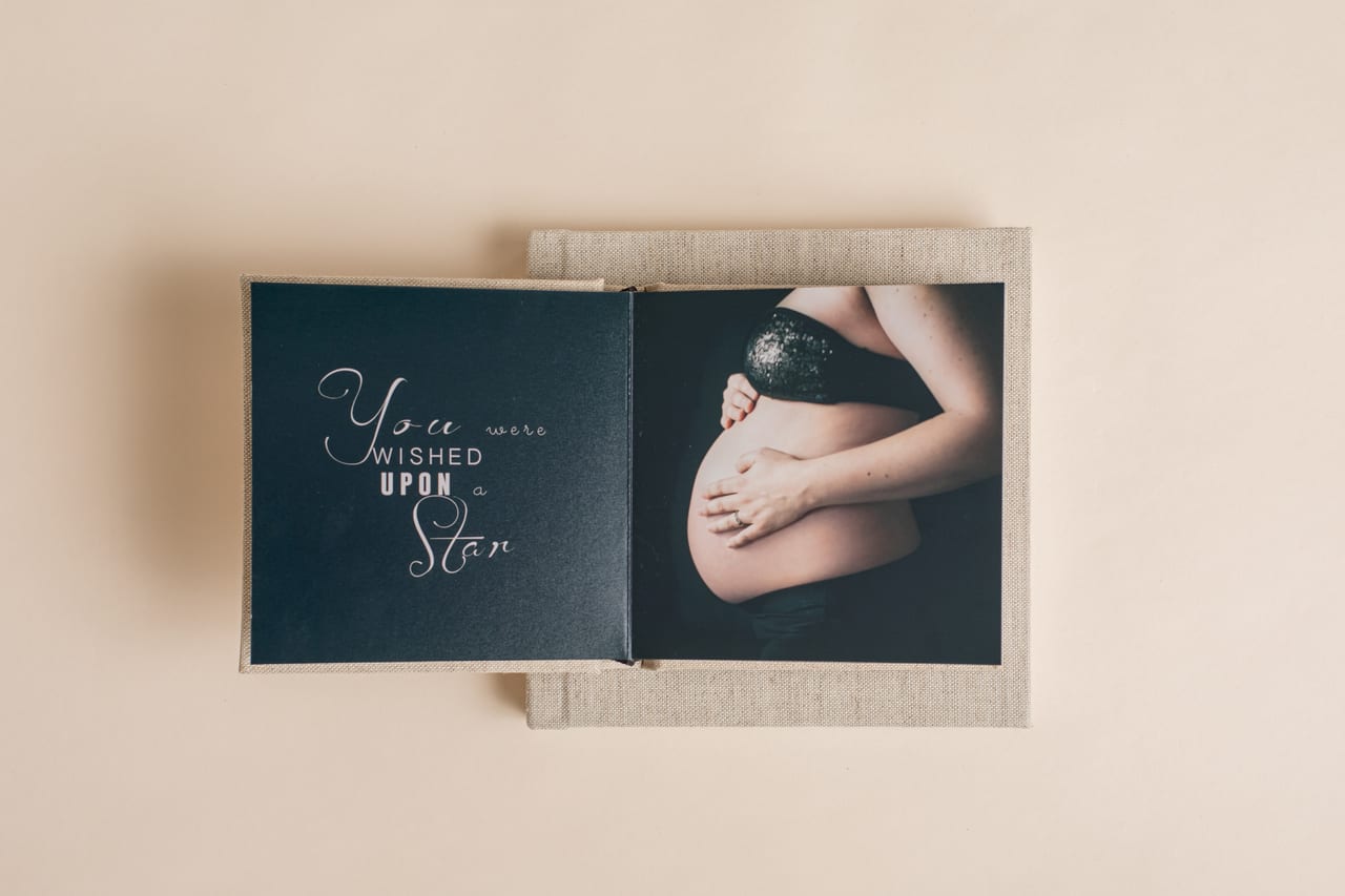 Spread interior de álbum em linho aberto, com a frase "You were wished upon a star" do lado esquerdo e fotografia de gravidez em close-up do lado direito, Susana Schmitz Fotografia, Porto